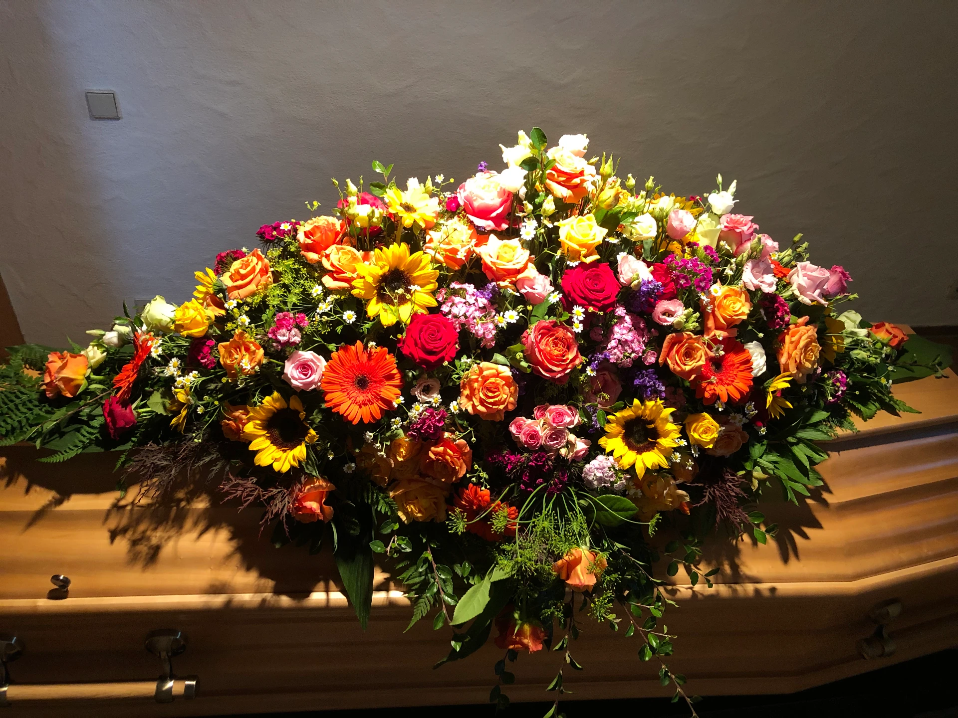 Farbenprächtiges Sarggesteck mit Rosen, Gerbera und Sonnenblumen