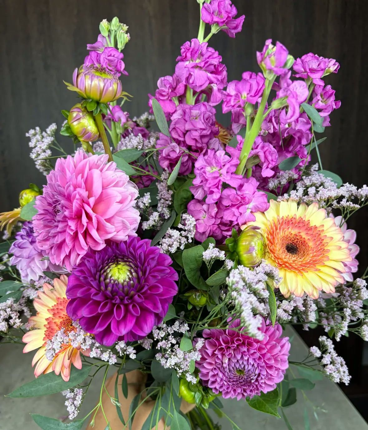 Üppiger frisch gebundener Strauß mit pinkfarbenen Dahlien, Levkojen, Gerbera und Schleierkraut